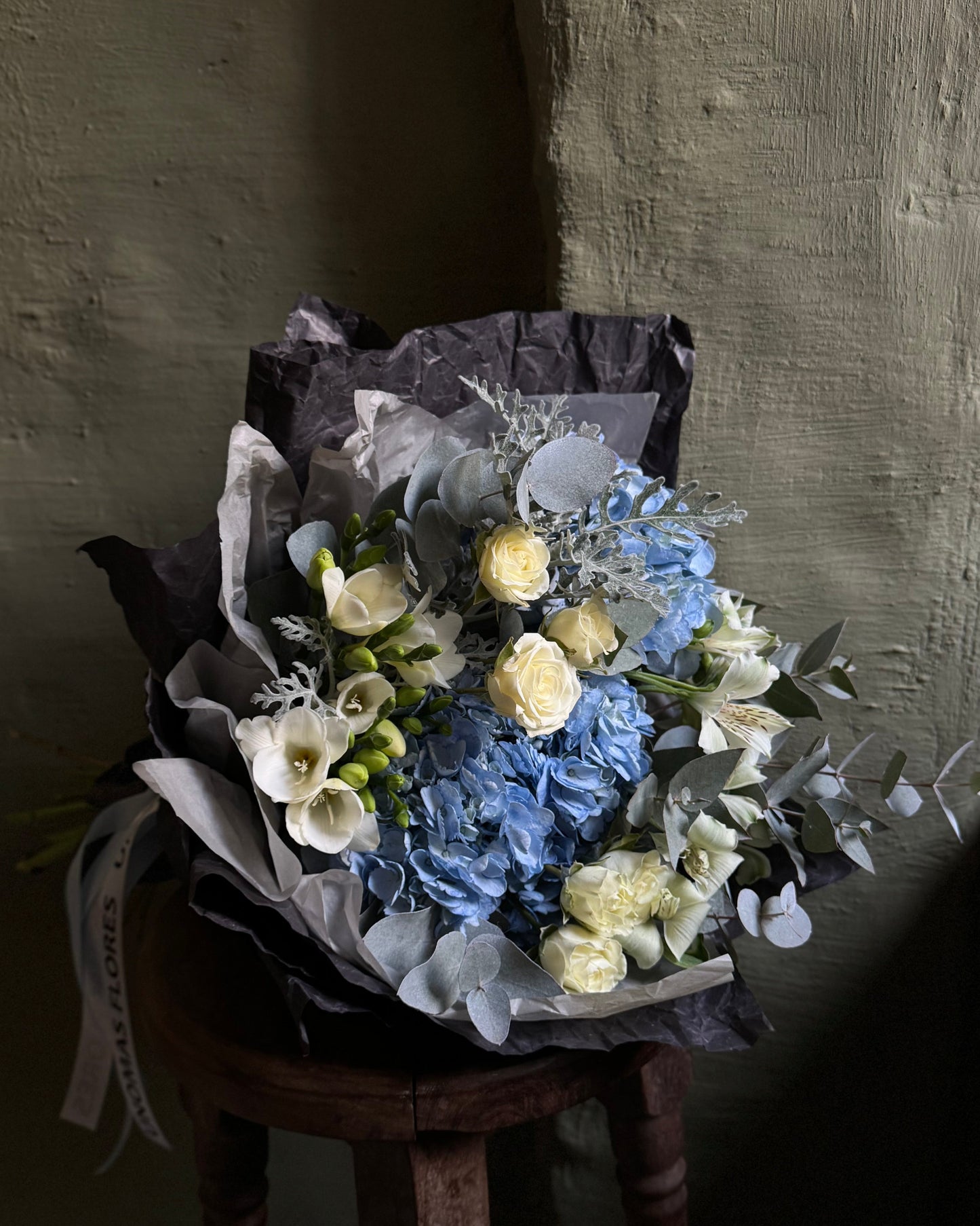 Mixed flower bouquet in dark gift paper