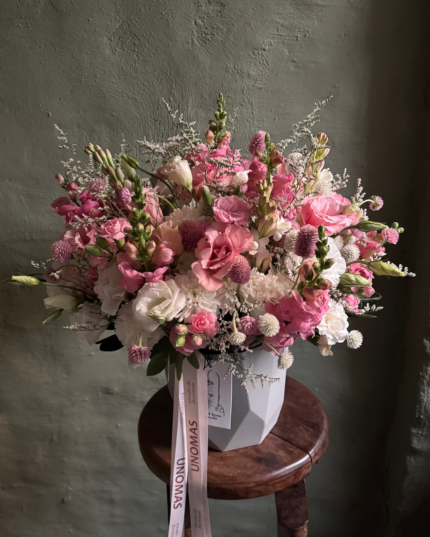Flower arrangement with pink lisianthus & gomphrenas in a white cachepot
