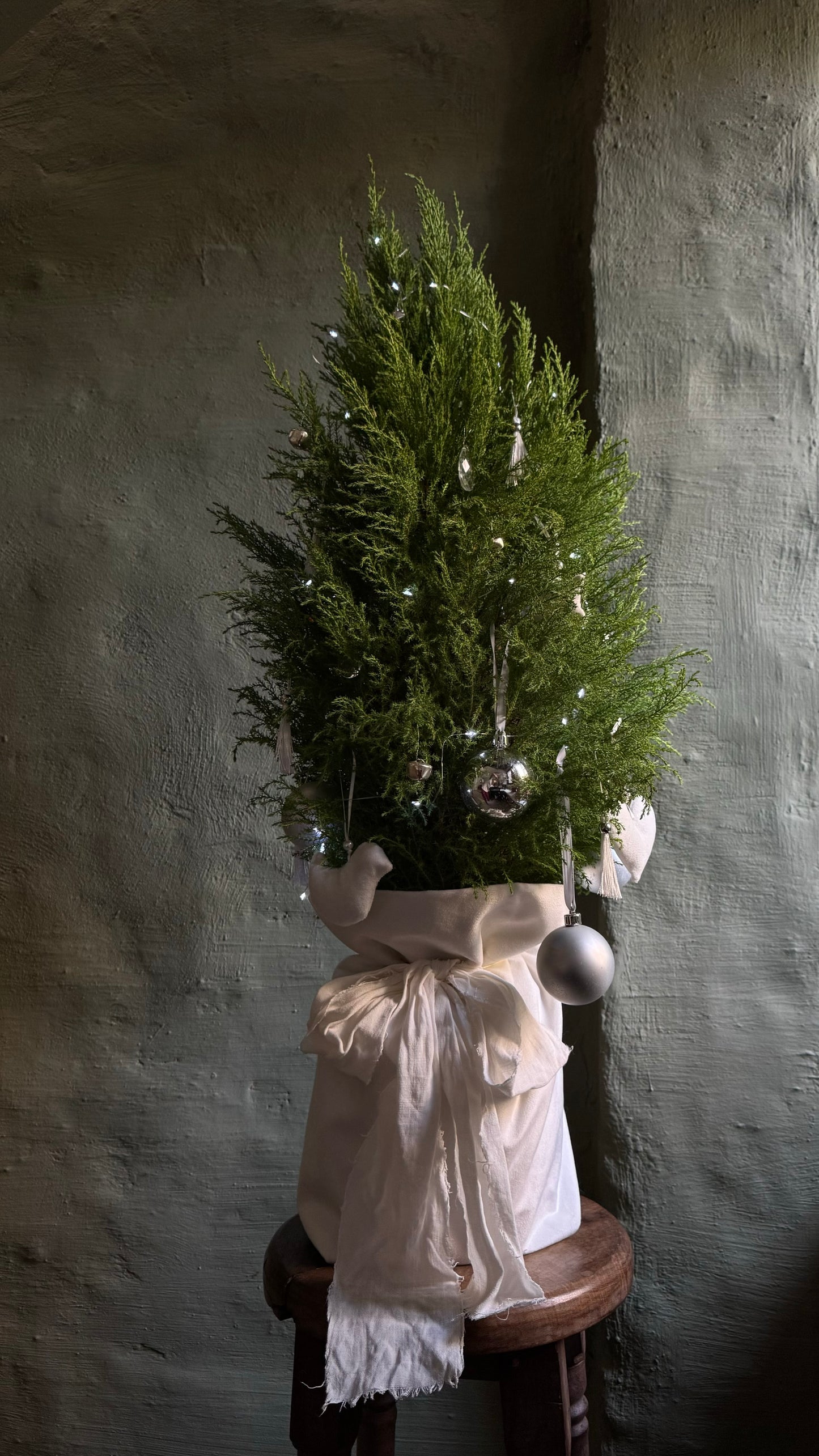Decorated Christmas tree with white lights & textile handcrafted toys in a pouch with a bow