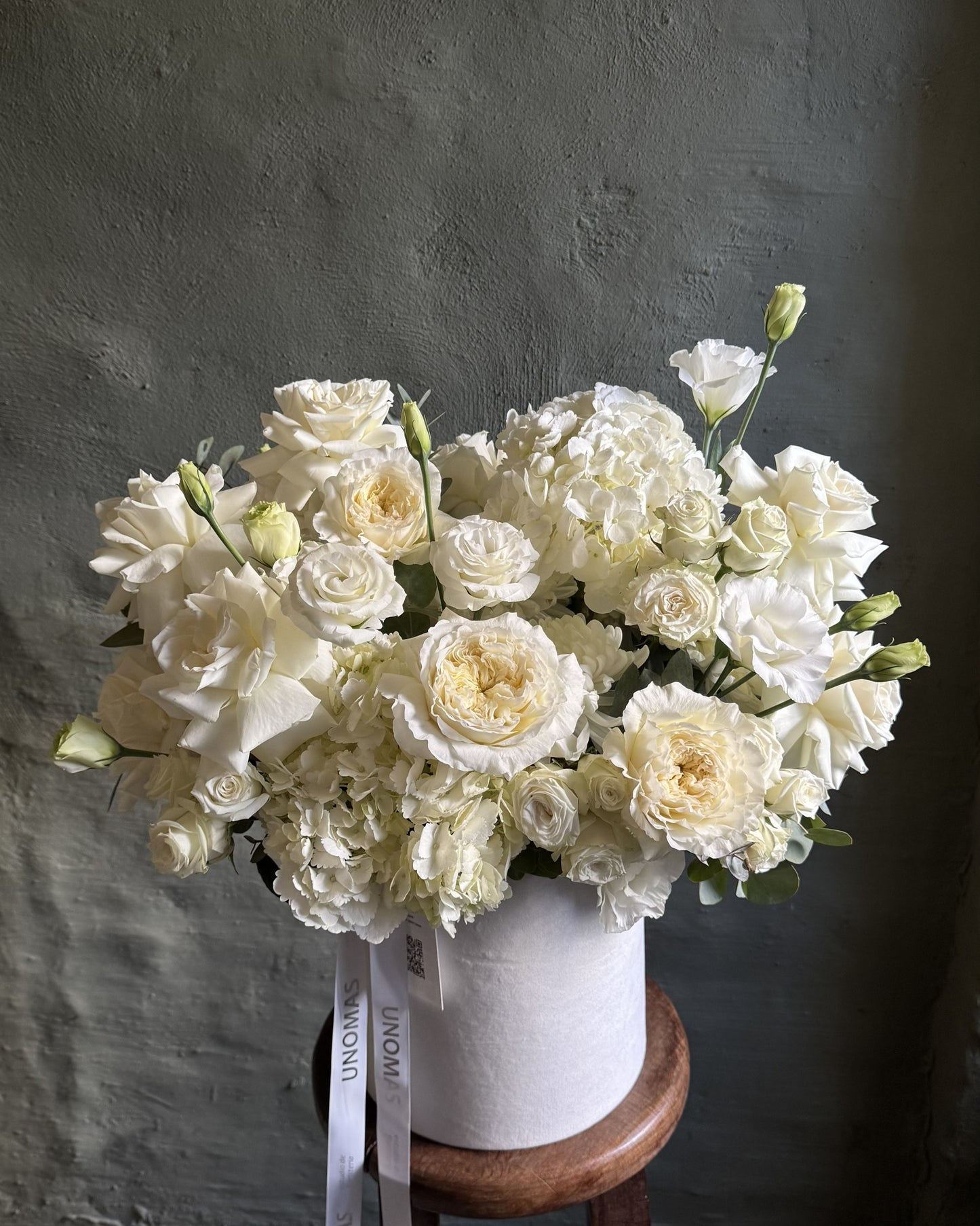 Arreglo floral con rosas y hortensias blancas y crema en una caja
