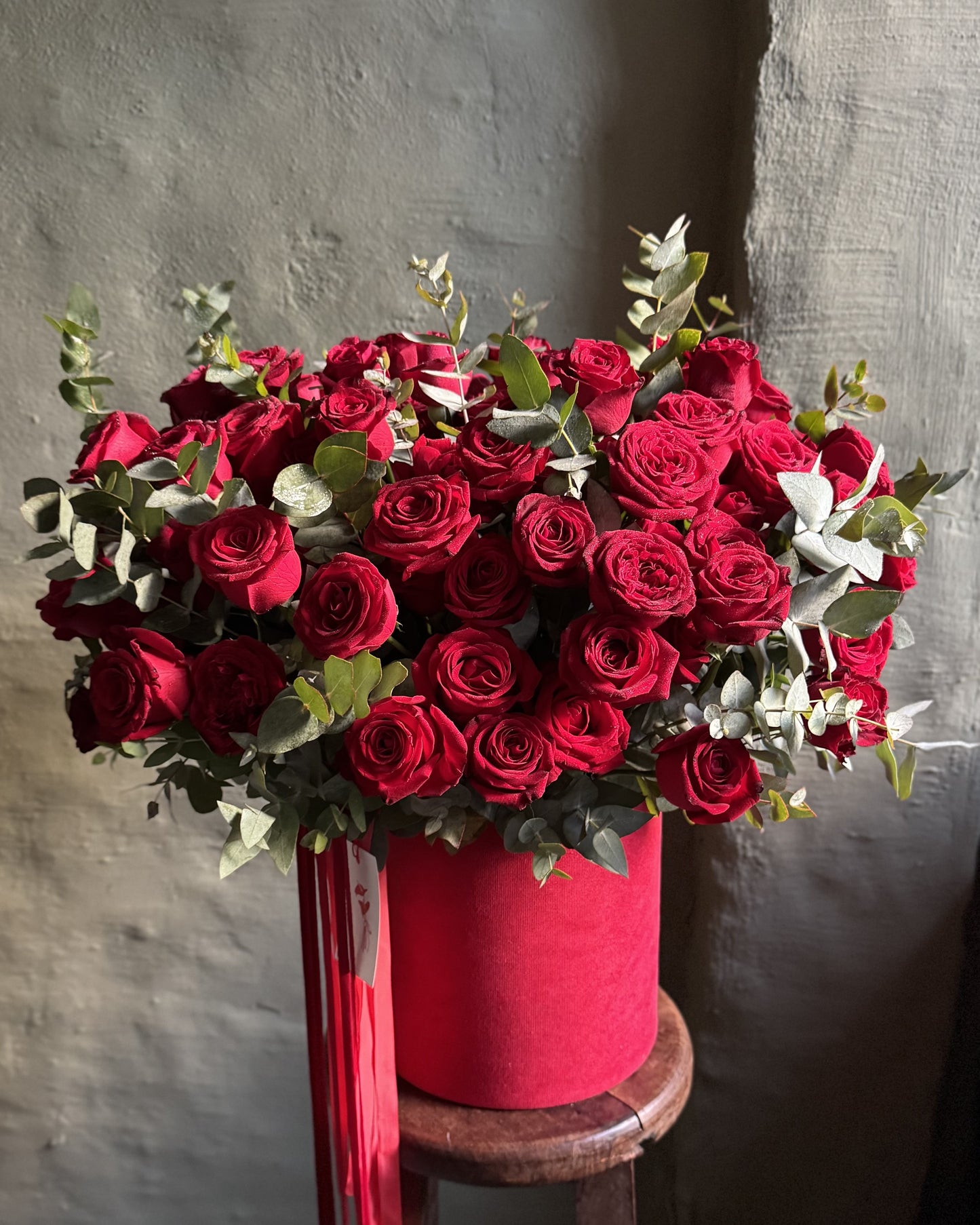 Flower arrangement big with red roses in a hat box