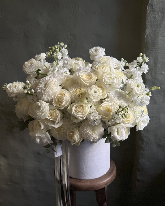 Bouquet of white flowers in a box on a dark background