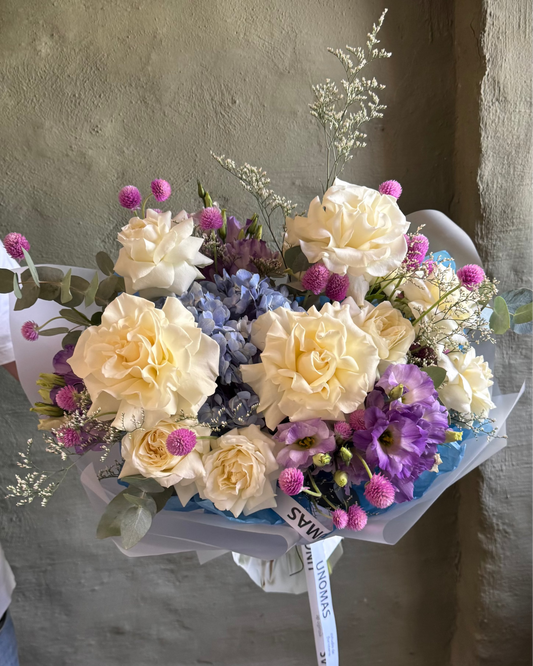 Bouquet of flowers blue and violet held against a textured wall