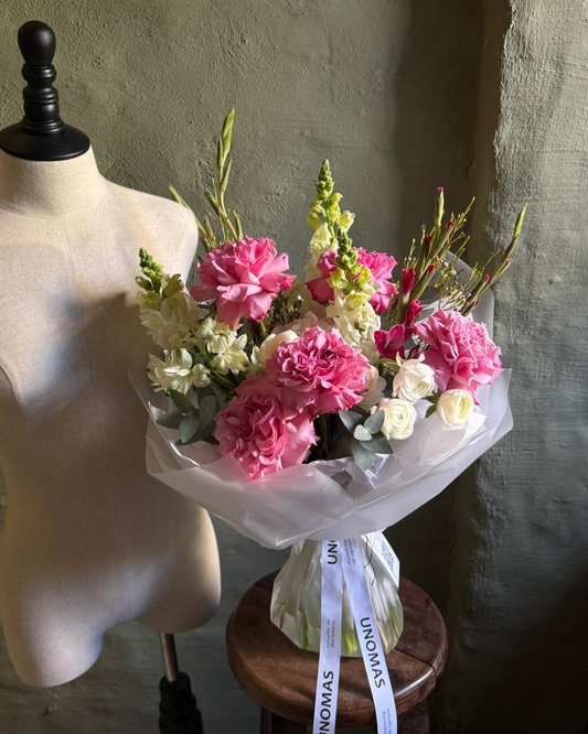 Bouquet of pink and white flowers on a mannequin bust against a neutral background