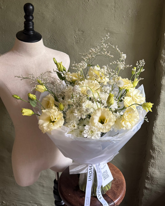Bouquet of yellow flowers on a mannequin torso against a textured wall.