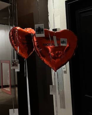 Decorative balloons and heart-shaped balloons in a room with mirrors and carpeted floor.