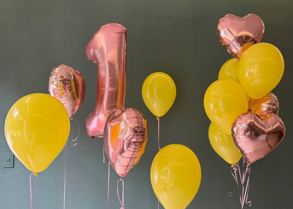 Decorative balloons including a large number '1' and heart shapes against a dark background