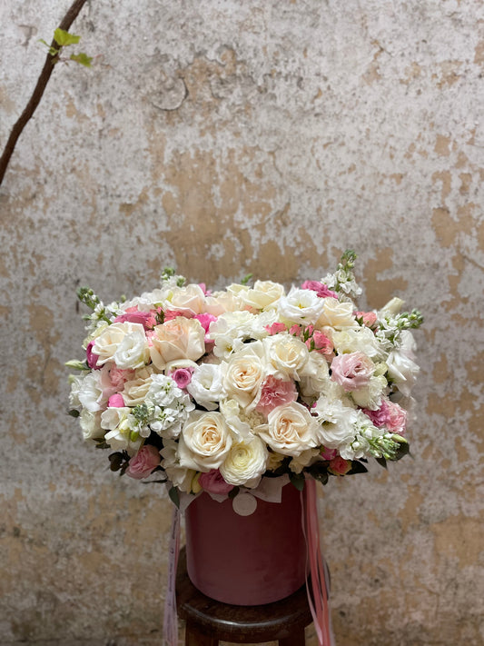 White & pink flower arrangement in a hat mix