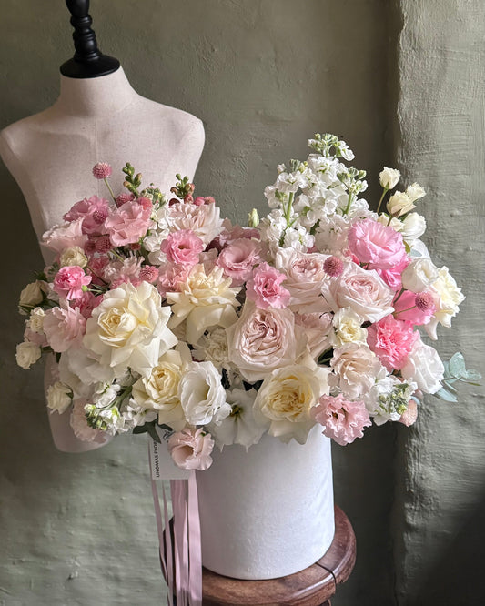 Flower arrangement delicate white & light pink in a hat box