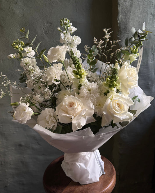 White mixed flower bouquet in pergament paper