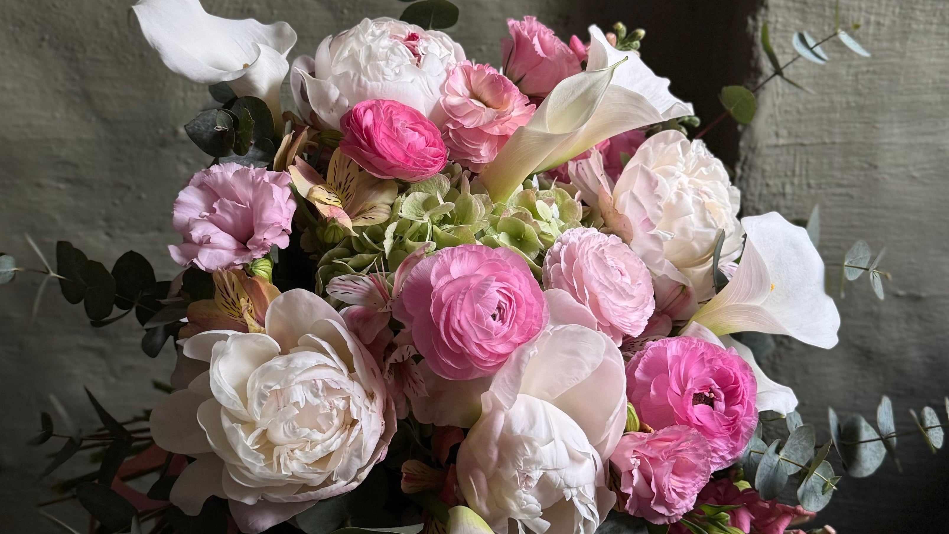 Bouquet of pink and white flowers against a dark background