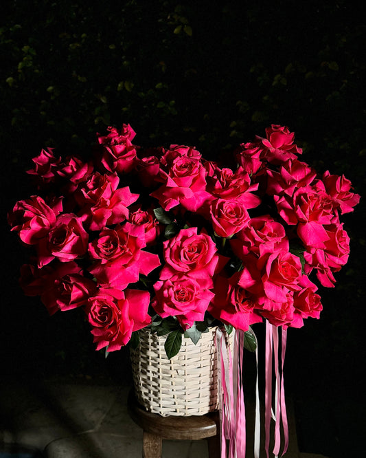 Bouquet of pink roses in a woven basket on a dark background