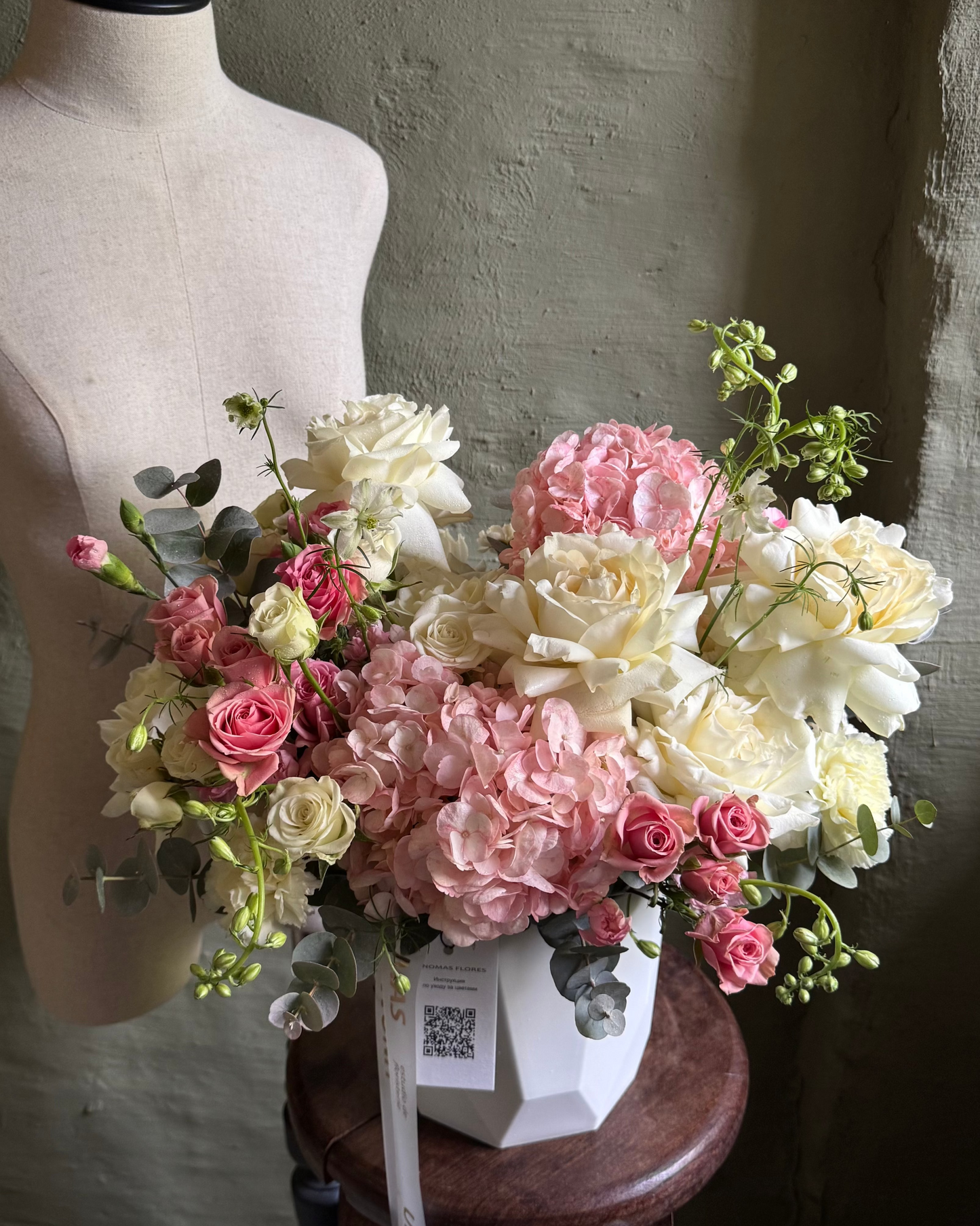 Arreglo floral en tonos suaves de rosa y blanco con hortensias y rosas en cachepot blanco
