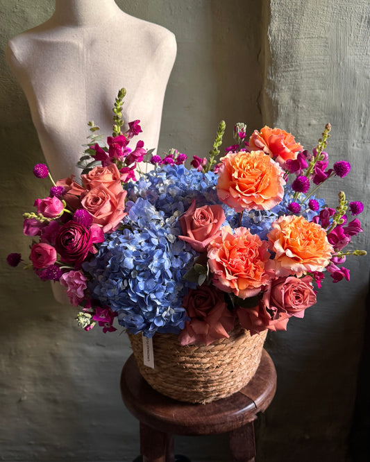 Flower arrangement bright colorful in a wicker basket