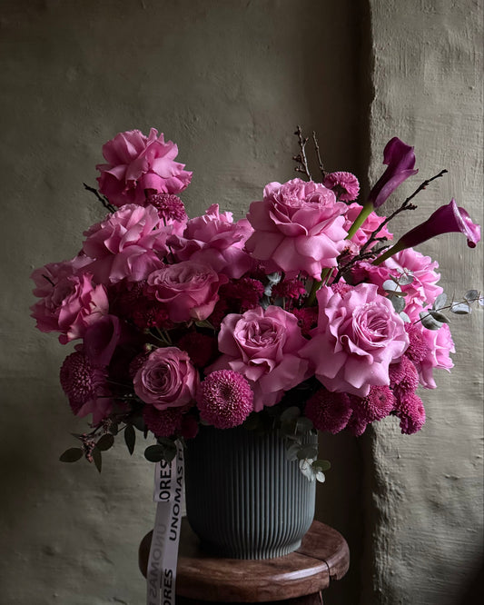 Flower arrangement purple with roses, chrysanthemums and calla lilies in a cachepot