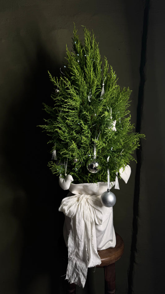 Decorated Christmas tree with white lights & textile handcrafted toys in a pouch with a bow