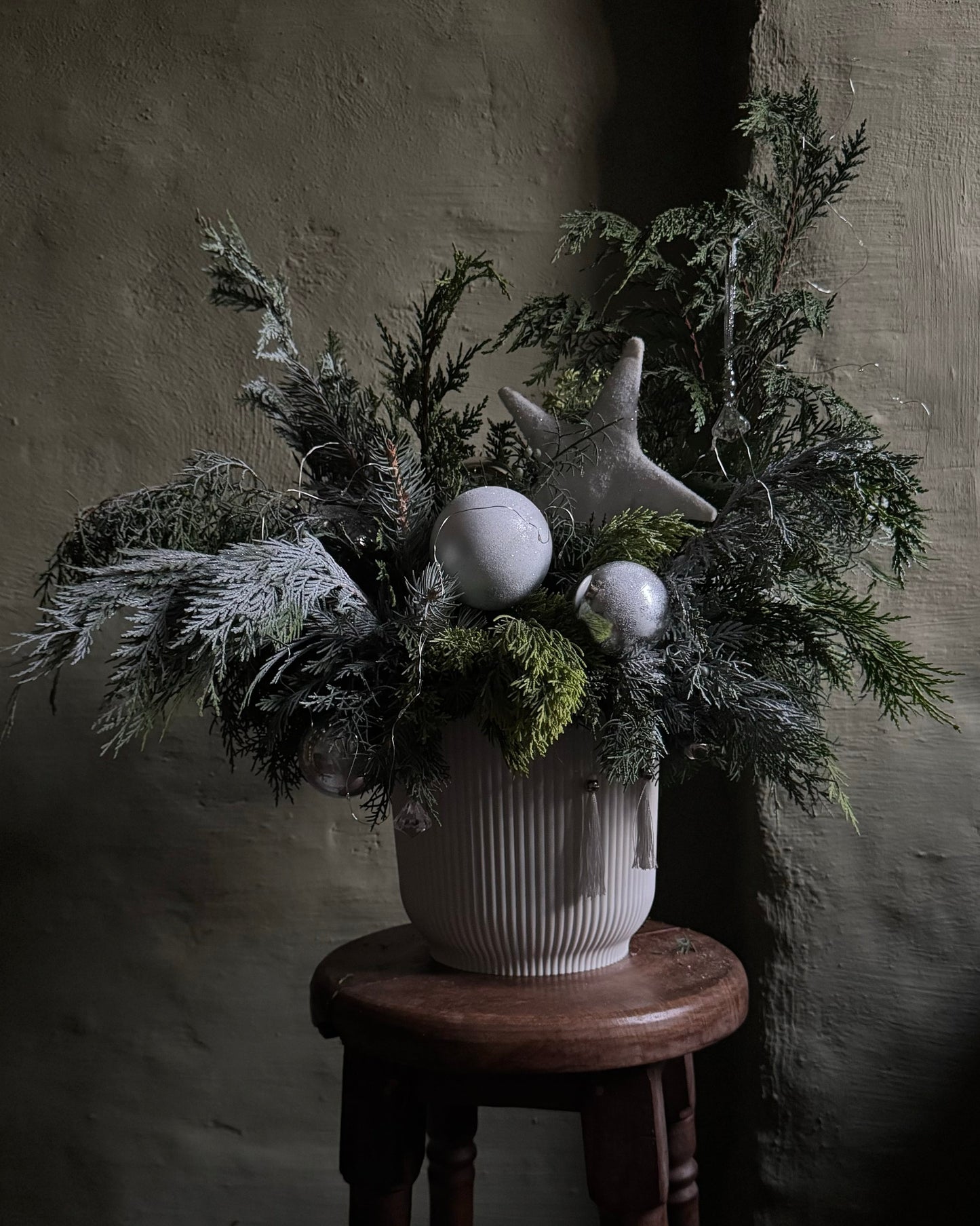 Decorated Christmas arrangement with silver lights & silver star & balls in a white cachepot