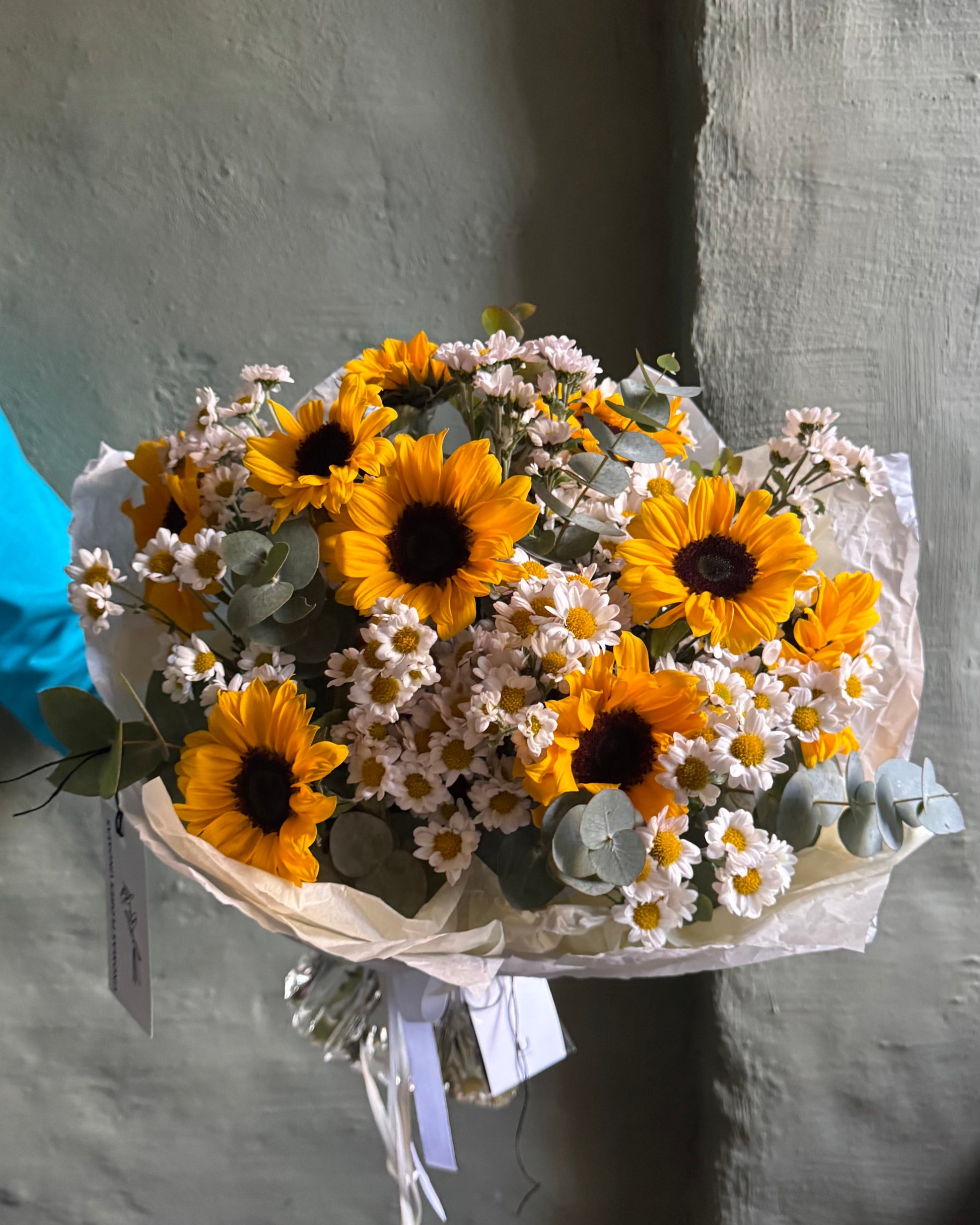 Bouquet of sunflowers and white flowers on a gray background