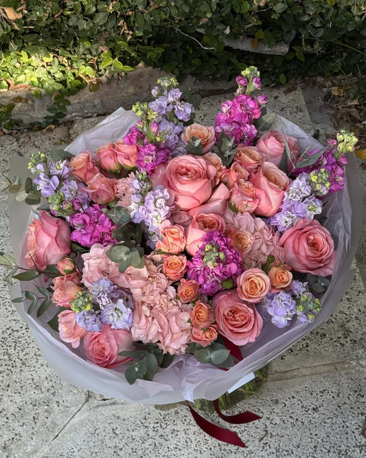 Ramo mixto de rosas ecuatorianas rosa durazno y matthiolas violetas envuelto para regalo