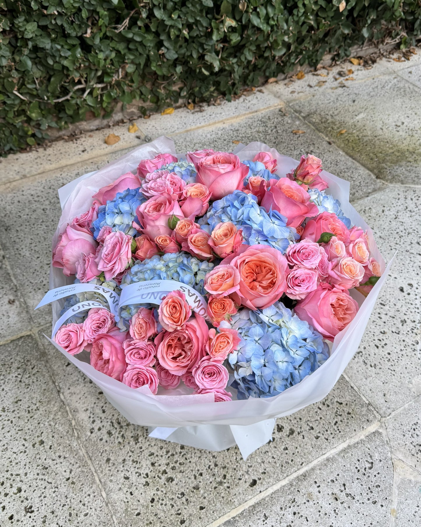 Ramo mixto de hortensias azules y rosas ecuatorianas rosa intenso envuelto para regalo