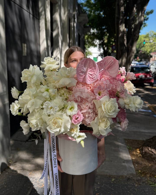 Person holding large bouquet with roses of flowers on a city street.