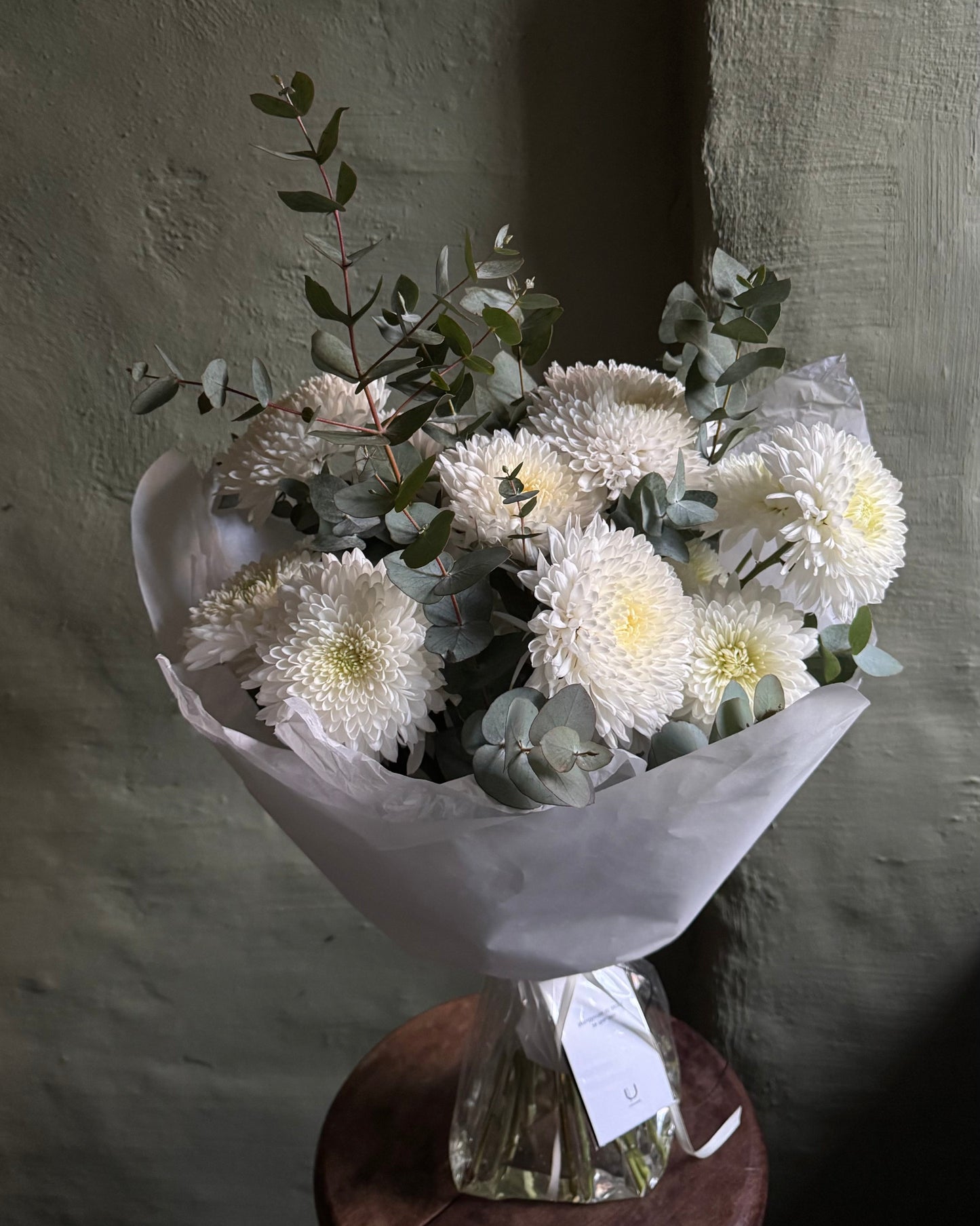 Ramo de flores blancas envuelto en papel