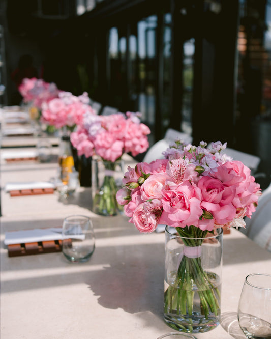 Table setting with pink floral arrangements in a modern indoor setting