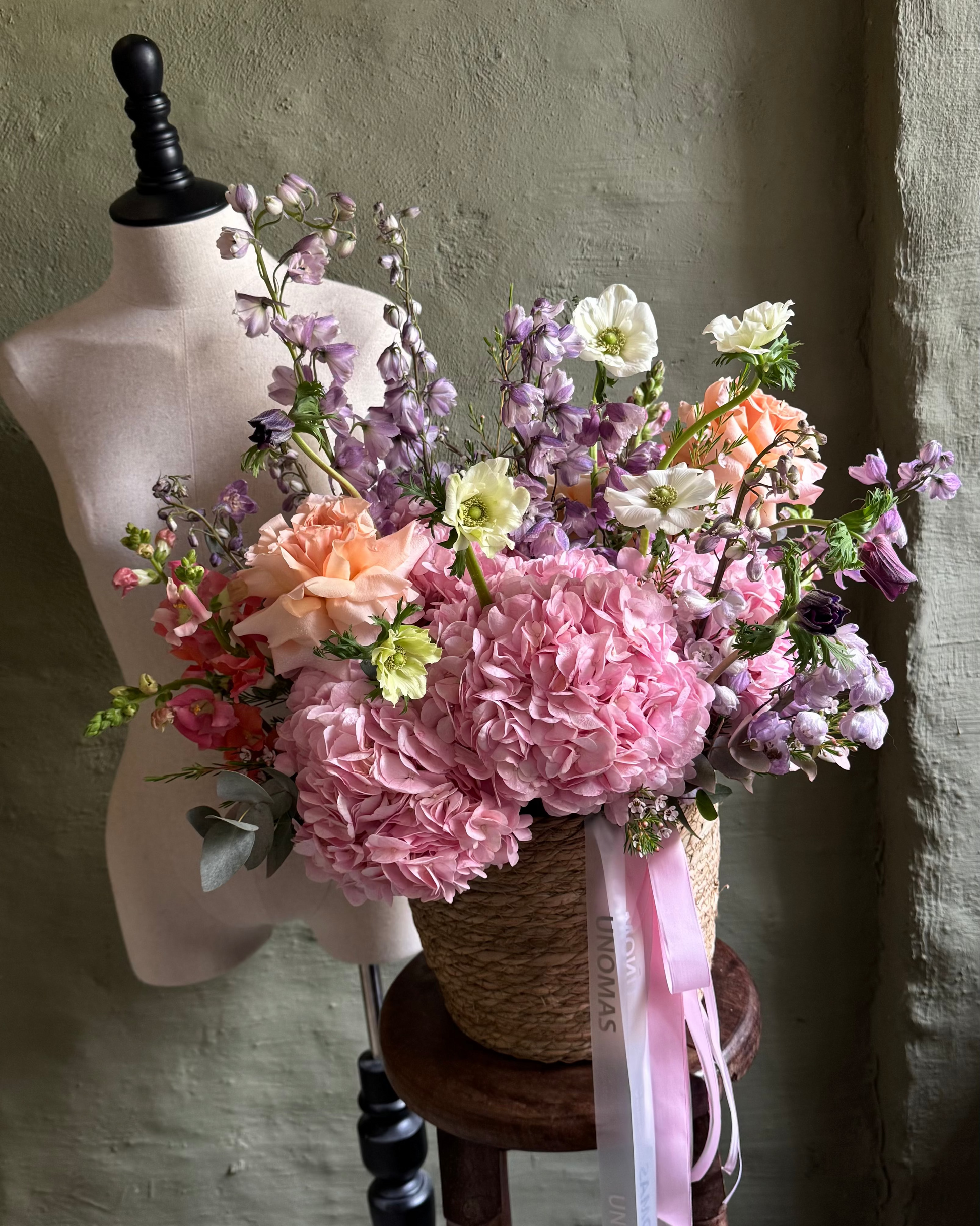 Arreglo floral de cuento en tonos rosa y naranja con hortensias y anémonas con rosas ecuatorianas