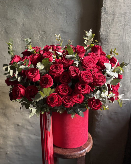 Flower arrangement big with red roses in a hat box
